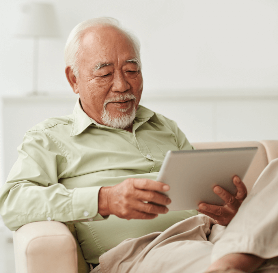 Senior man scrolling through his tablet