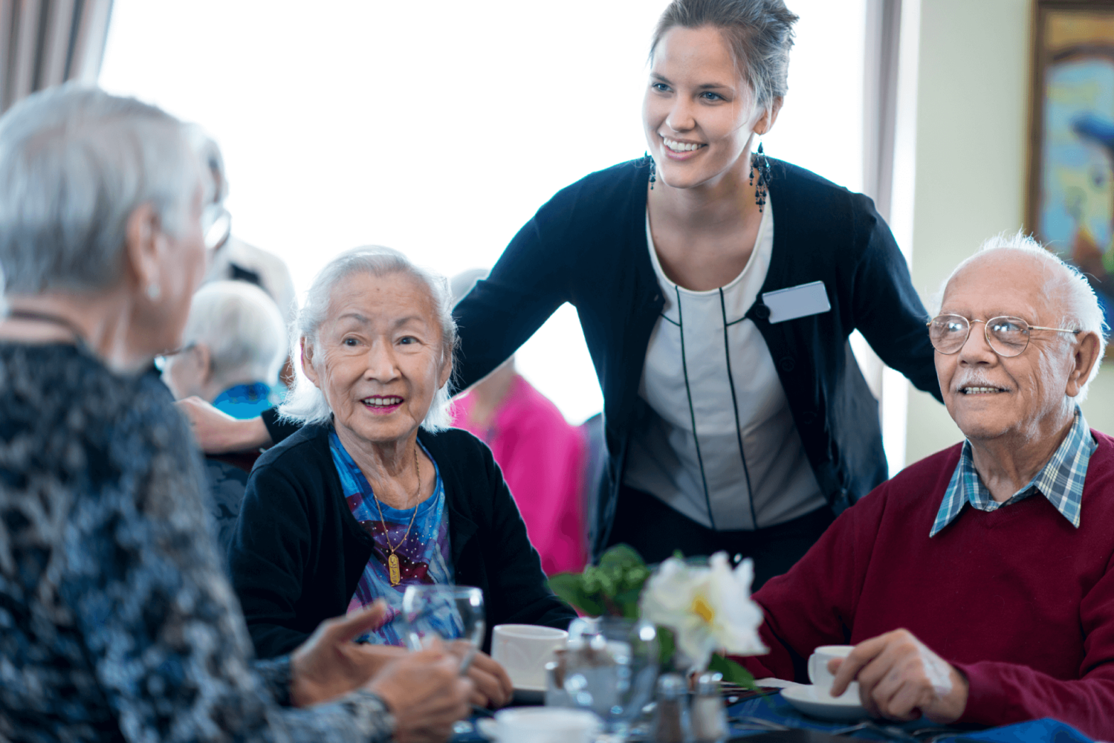 Staff member checking in on seniors as they dine