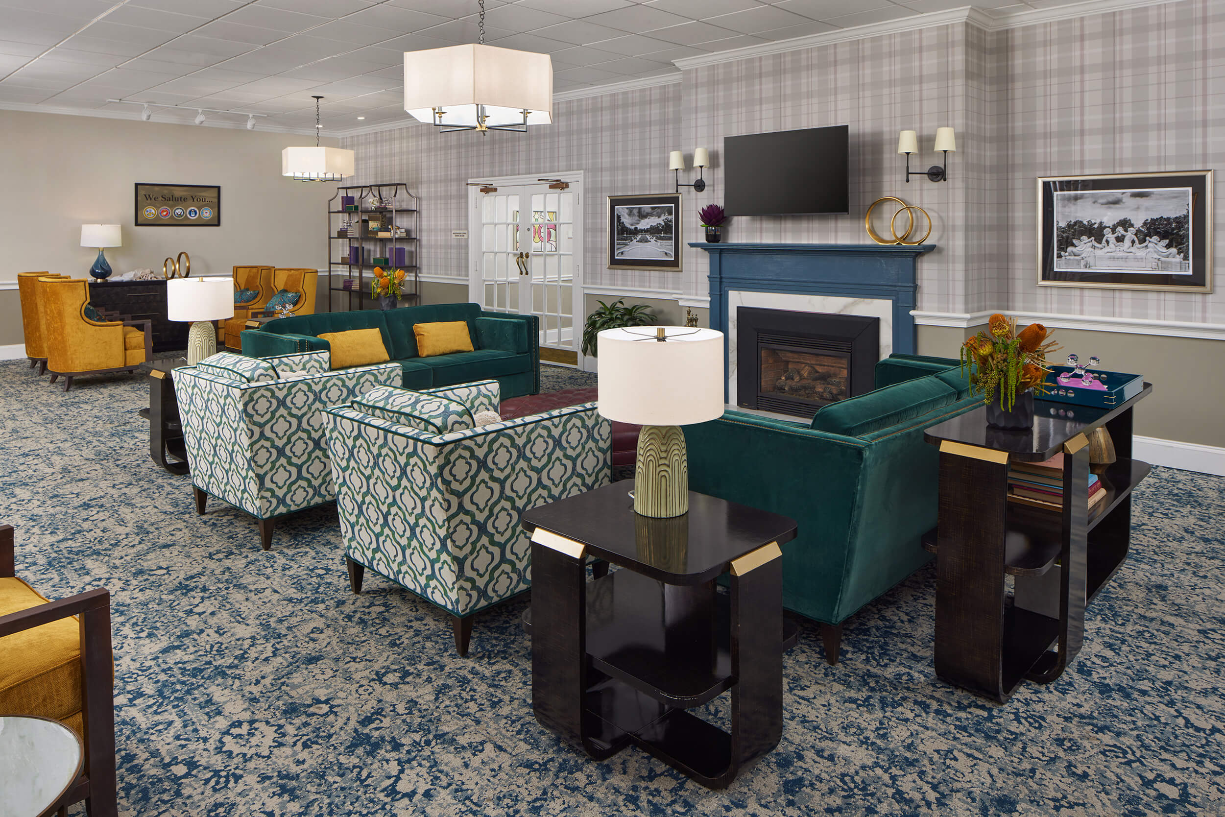 Elegant common room with seating, fireplace, and decor at a senior living community.