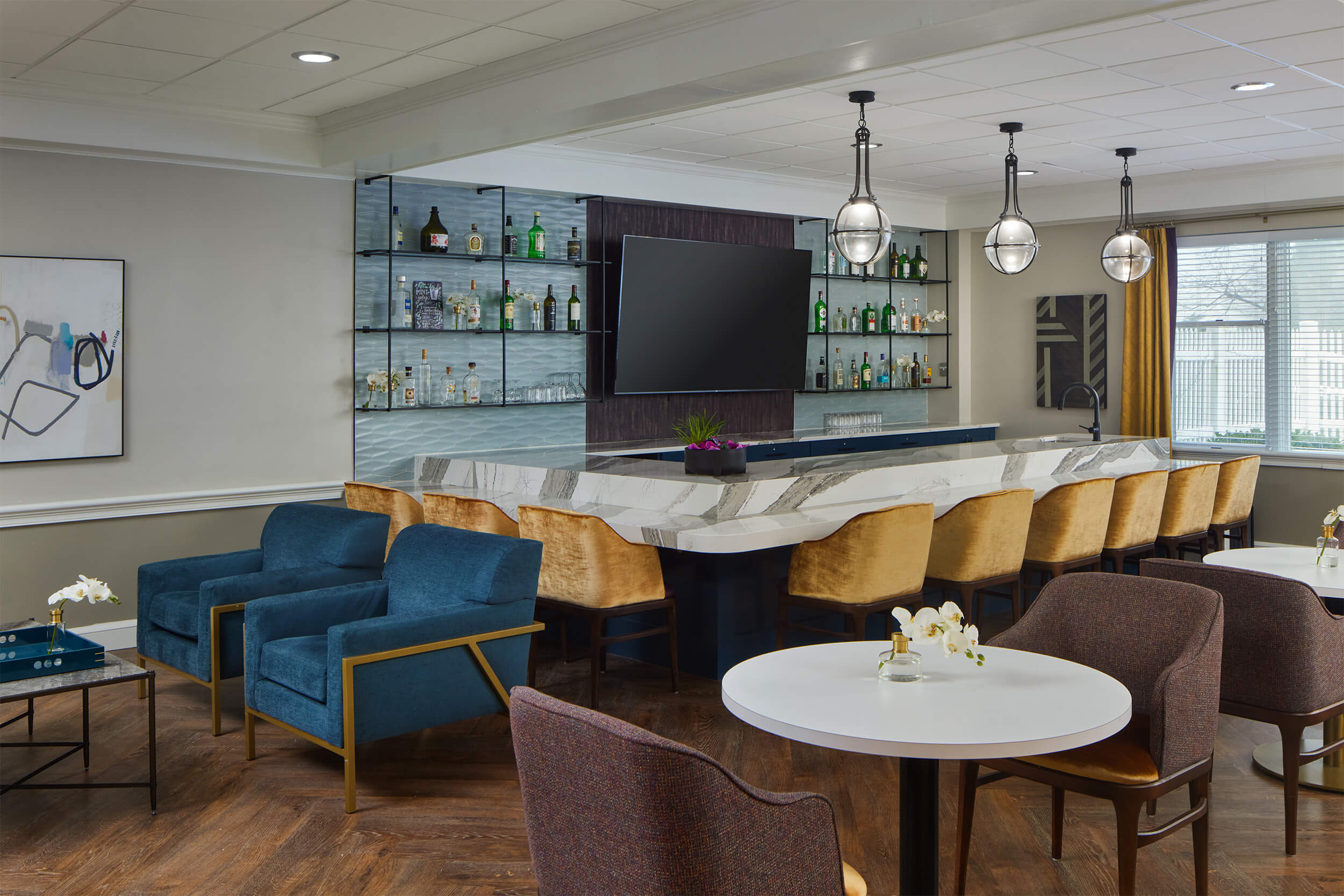 Modern lounge area with bar, seating, and decor at a senior living community.