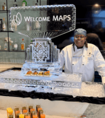 Chef Renee smiling beside a decorative ice sculpture.